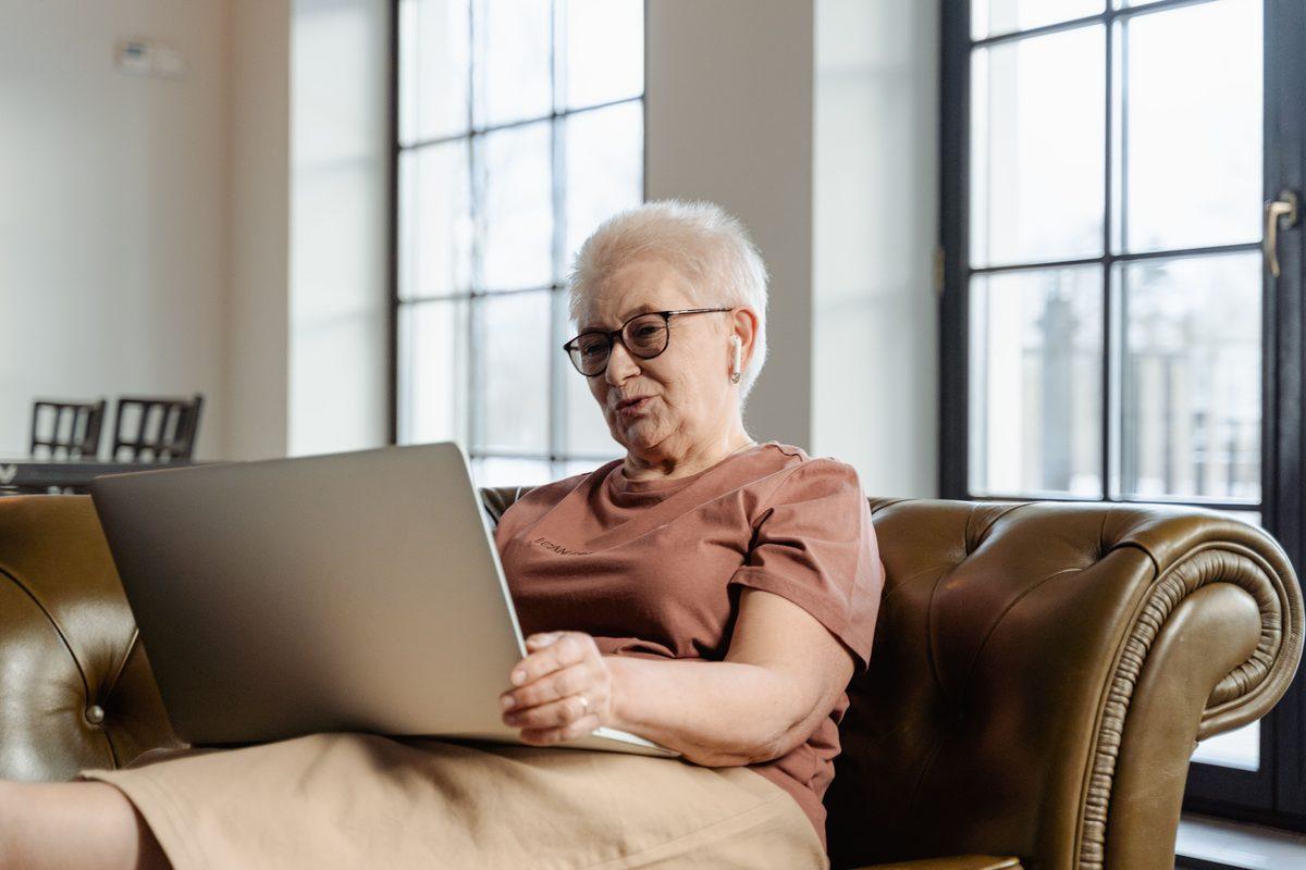 Older woman using a laptop on her sofa